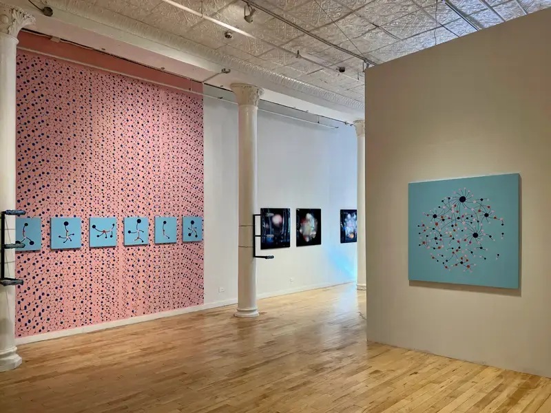 Gallery wall printed with red networks, with blue network paintings in a row