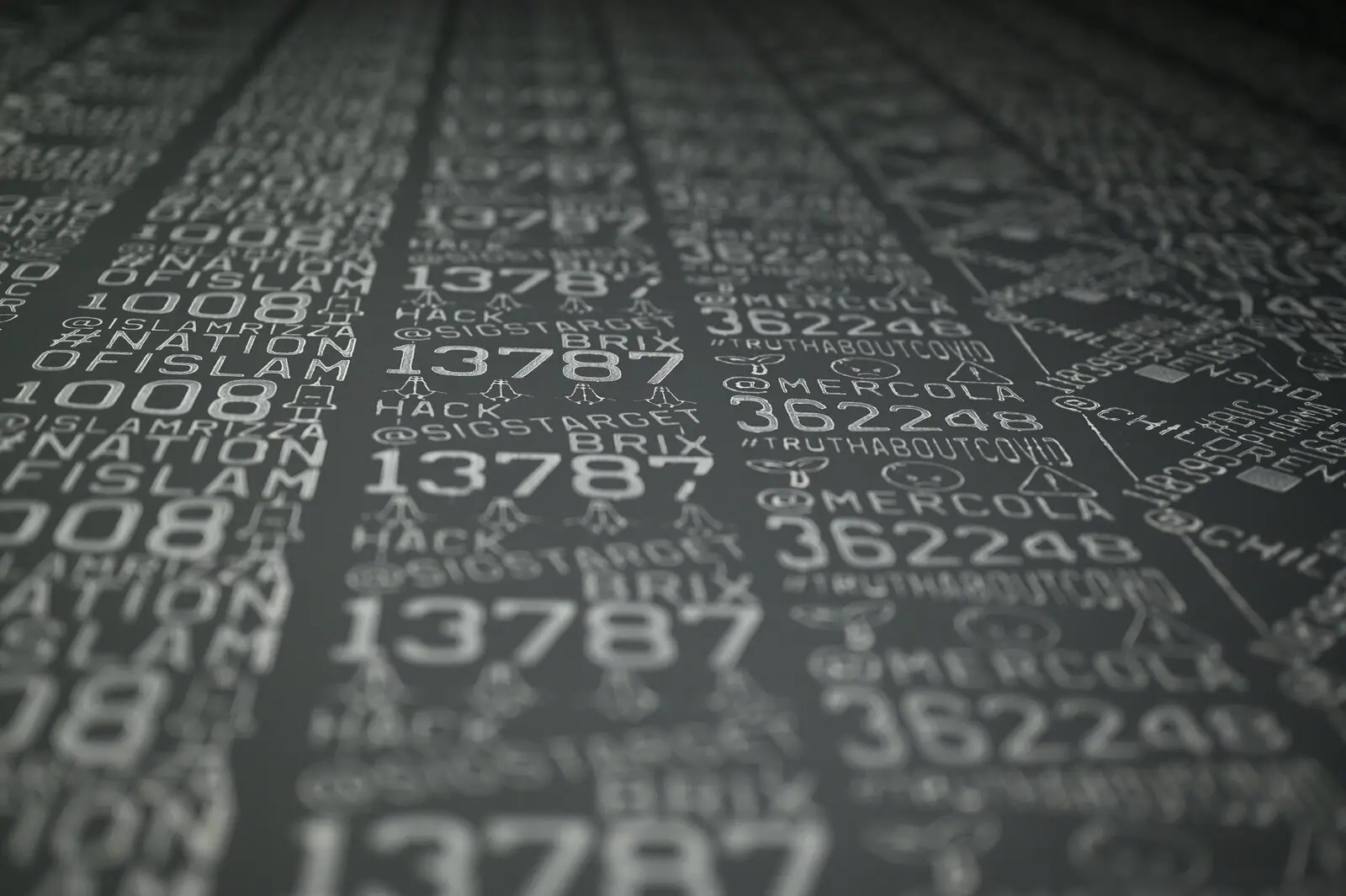 Close-up of grey paper printed by roller with numbers, hashtags and account names